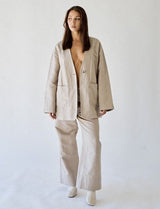 Woman wearing a beige suit against a white background
