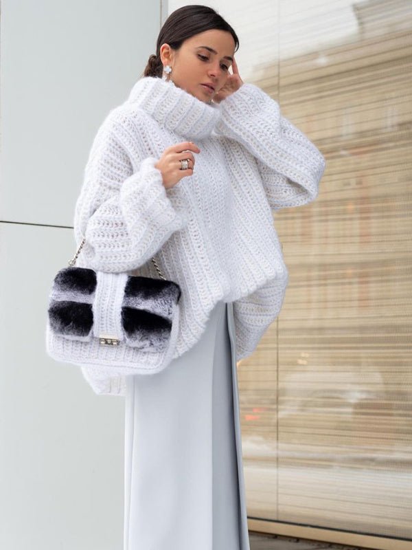 Woman wearing the Rainy Dayz Sweater in white, styled with a grey maxi skirt and black-and-white faux fur handbag.