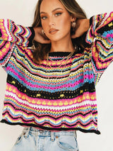 Model in Pink Blush Print Rich In Time Sweater with hands raised, highlighting the loose fit.