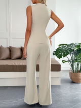 Woman wearing a beige jumpsuit in a modern living room.