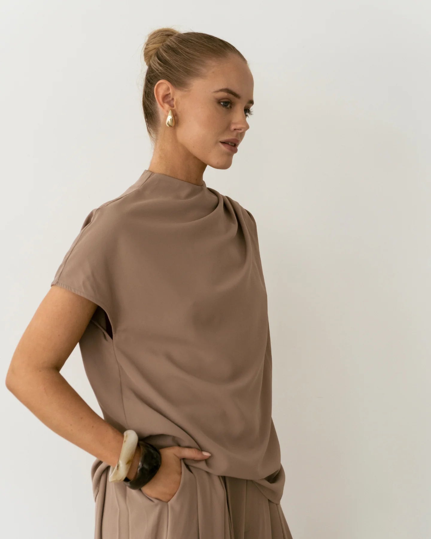 Side profile of Sharee Top showing relaxed fit and short sleeve shape.