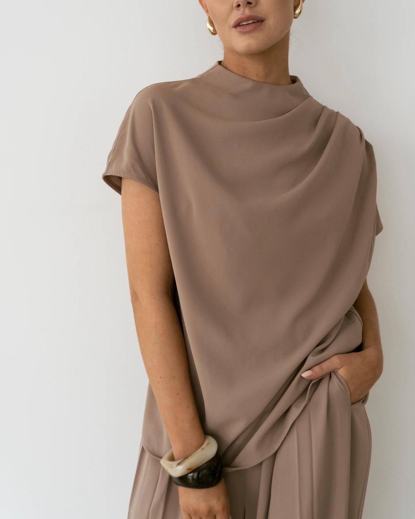 Close-up of Sharee Top paired with belt, highlighting neckline and smooth finish.