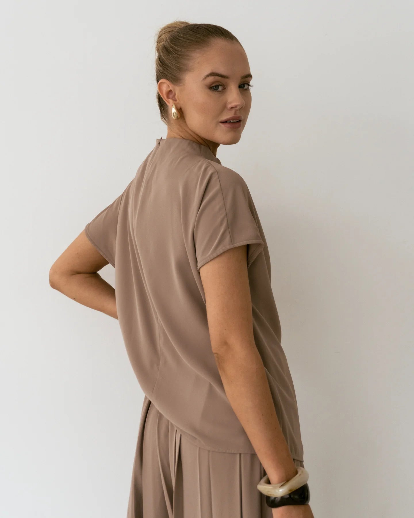 Detail of Sharee Top sleeve and shoulder with soft drape and taupe tone.