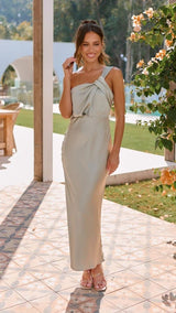 Woman in a light-colored dress standing outdoors with a scenic background