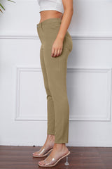 Person wearing olive green pants against a white wall