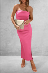 Woman wearing a pink strapless dress holding a beige clutch against a gray background