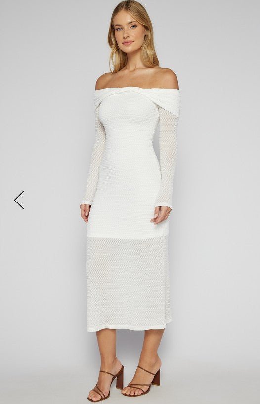 Woman wearing a white off-shoulder dress on a plain background