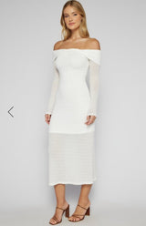 Woman wearing a white off-shoulder dress on a plain background