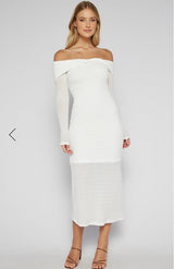 Woman wearing a white off-shoulder dress against a plain background