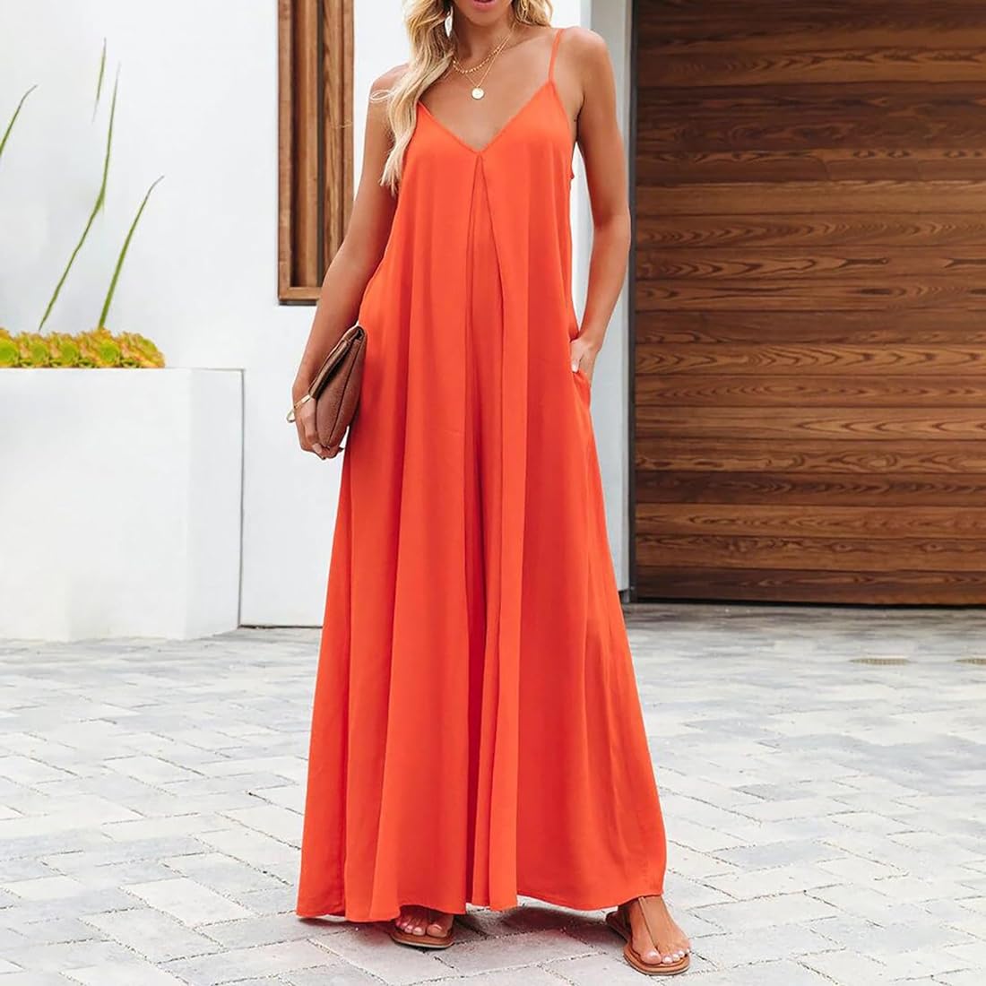 Side view of The Harlot Jumpsuit in orange, showing flowy wide-leg fit and v-neckline.