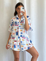 Woman wearing exclusive Frankie printed playsuit, collared neckline and button-up front.
