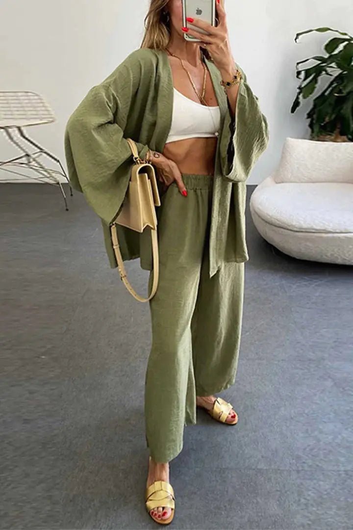 A model wearing the Zafira Pants and Cardigan Two Piece Set in olive green styled for a casual outing.