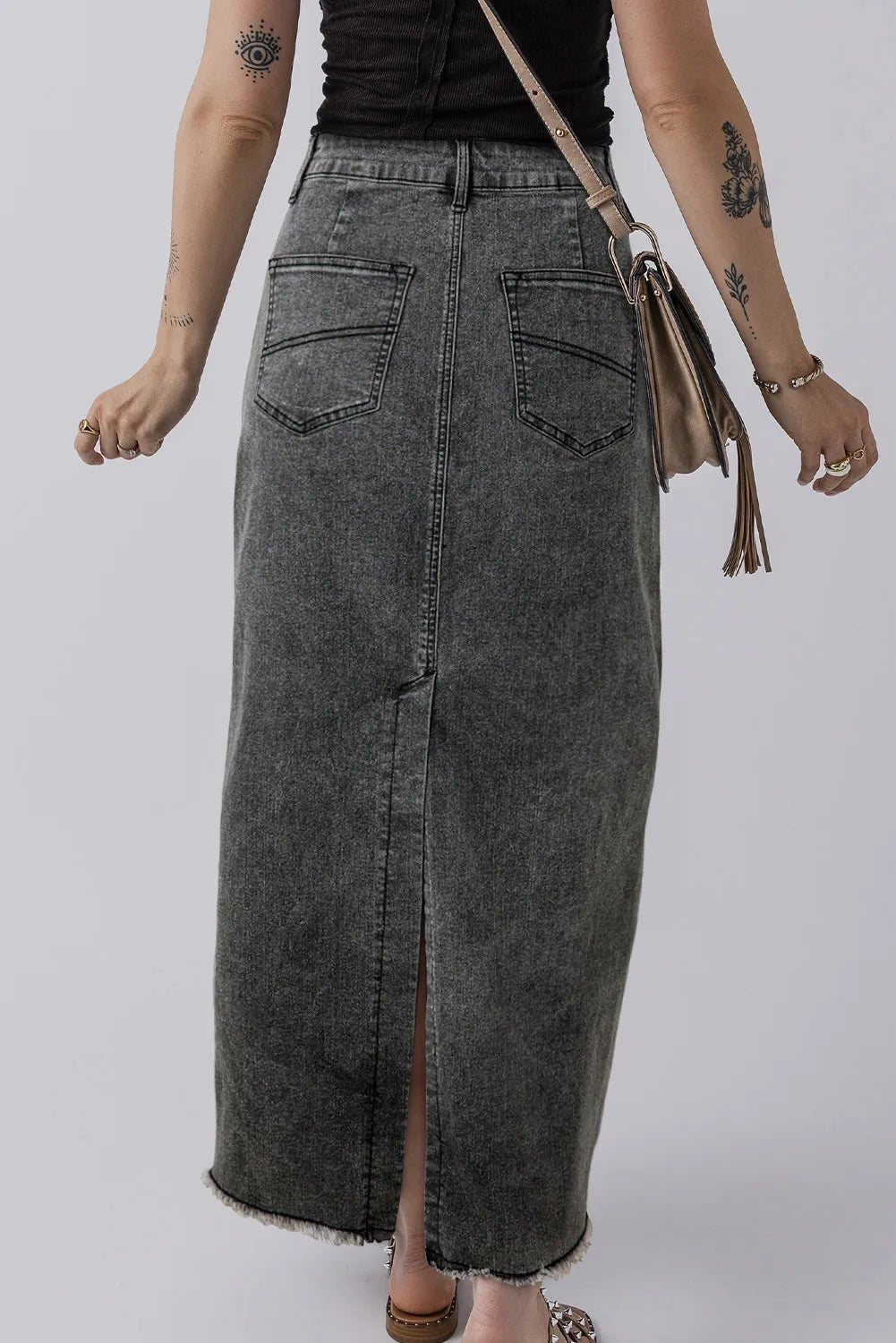 Back view of the Zuri Maxi Denim Skirt in Black showing slit detail and pocket placement.