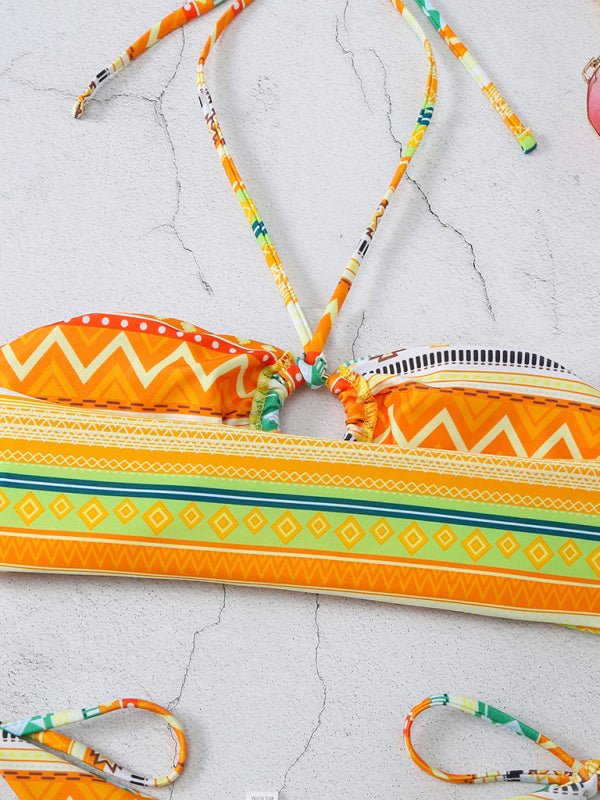 Yellow-orange bikini top and bottoms with tribal print laid flat on white background.