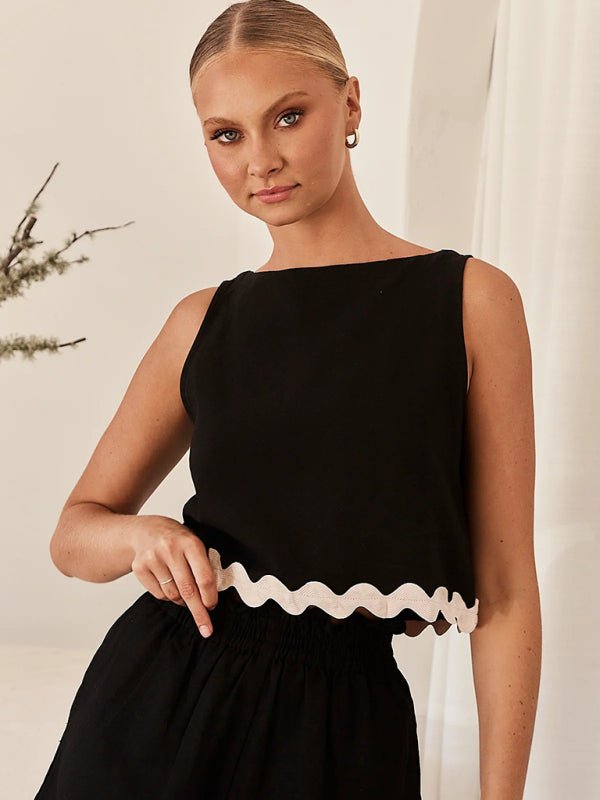 Model wearing the Allessa Black 2 Piece Set with white wave trim detail.