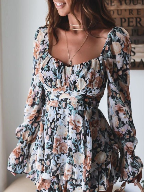 Woman wearing the Belladonna Floral Playsuit in black, showcasing the lantern sleeves and floral print.