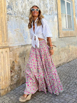 Flowing motion of the soft pink boho skirt captured mid-step, styled with a white blouse and espadrille wedges.