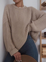 Woman wearing the More Of Me Knit in khaki, paired with blue jeans, leaning against a wall.