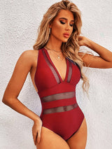 A model wearing the One-Piece Mesh Swimsuit in red with deep plunge neckline and mesh waist detail.