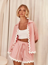 Model wearing Opal 2 Piece Set in pastel pink with scalloped hem shorts and cropped jacket.