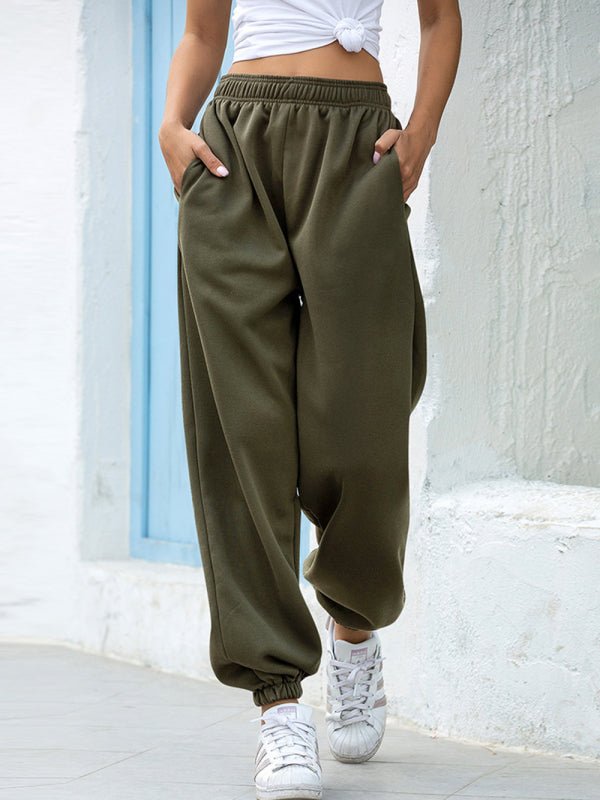 Person wearing olive green jogger pants with a white background