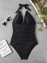 Black halter one‑piece swimsuit laid flat, showing back tie details and flattering fit