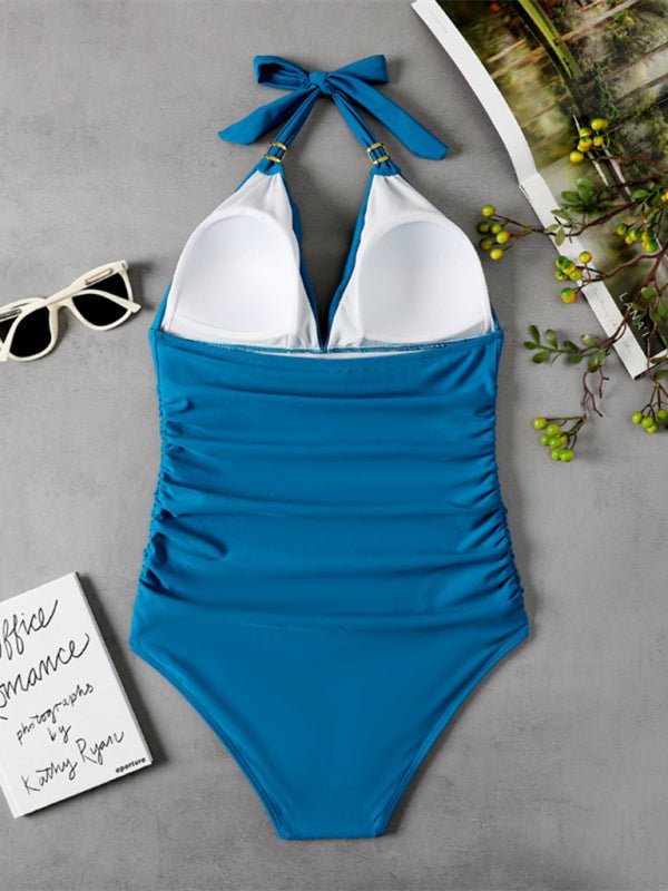 Sea‑blue halter one‑piece swimsuit laid flat, showing back tie and smooth finish