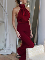 Model wearing The Blathin Jumpsuit in burgundy, featuring halter neckline and tailored fit.