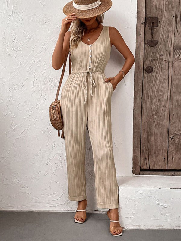 Front view of model wearing The Donatella Jumpsuit in beige with ribbed texture and button front, styled with straw accessories.