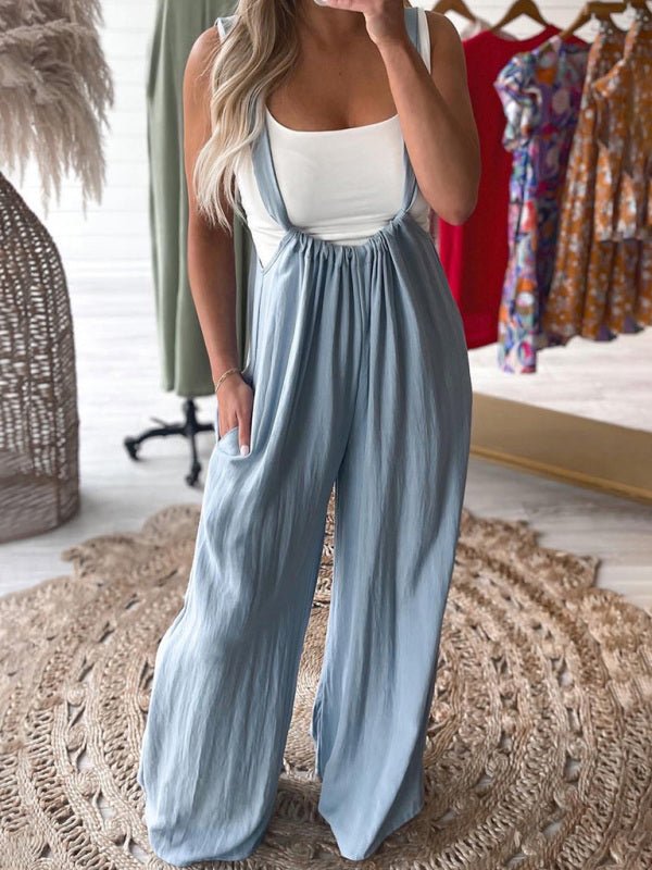 Woman wearing The Etana Overall Jumpsuit in light blue, wide-leg rayon jumpsuit with suspender straps.